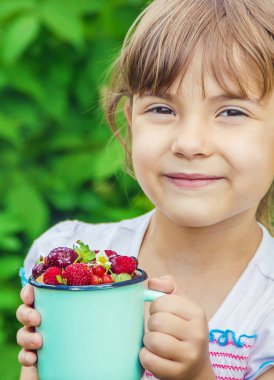 Çocuk bahçede kiraz topluyor. Seçici odak.