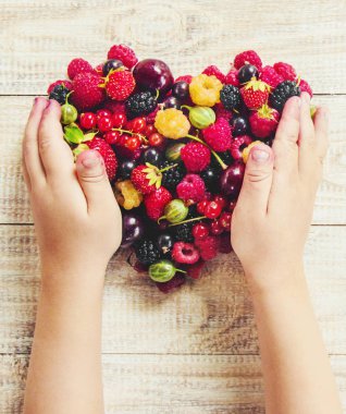 Çocuk bahçede kiraz topluyor. Seçici odak.