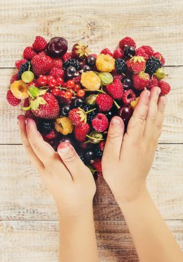 Çocuk bahçede kiraz topluyor. Seçici odak.