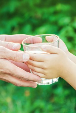 Baba çocuk bir bardak su verir. Seçici odak.