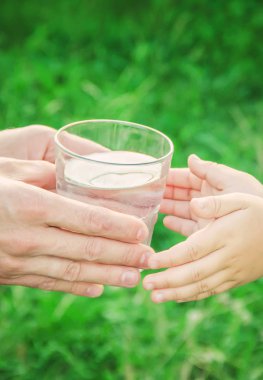 Baba çocuk bir bardak su verir. Seçici odak.