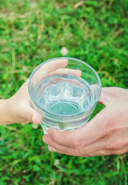 Baba çocuk bir bardak su verir. Seçici odak.