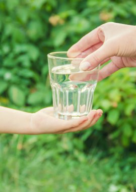 Baba çocuk bir bardak su verir. Seçici odak.