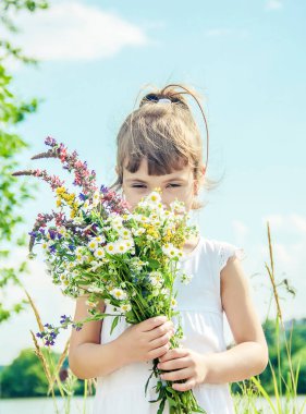 Bir buket kır çiçeği olan çocuk. Seçici odaklama.
