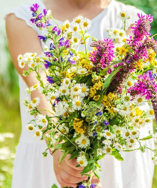 Kind mit einem Strauß Wildblumen. Selektiver Fokus. — Stockfoto