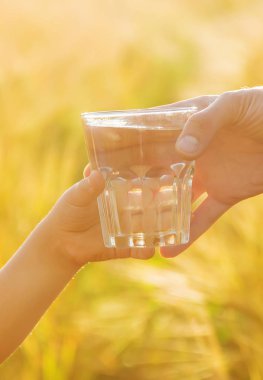 Baba çocuk bir bardak su verir. Seçici odak.