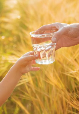 Baba çocuk bir bardak su verir. Seçici odak.