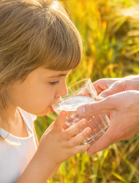 El padre le da al niño un vaso de agua. Enfoque selectivo . — Foto de Stock