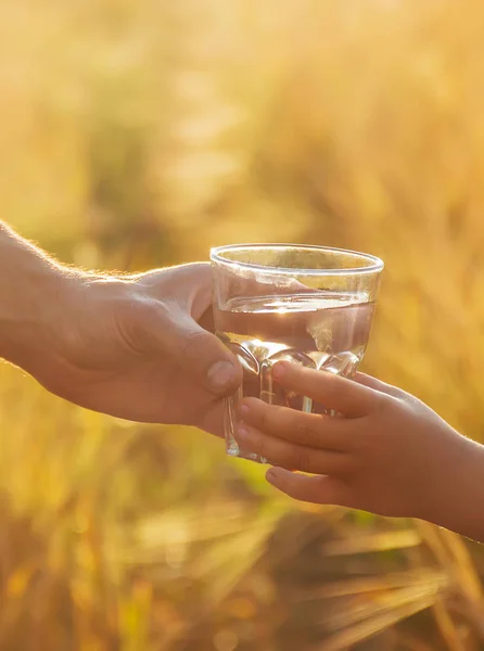 Fadern ger barnet ett glas vatten. Selektivt fokus. — Stockfoto