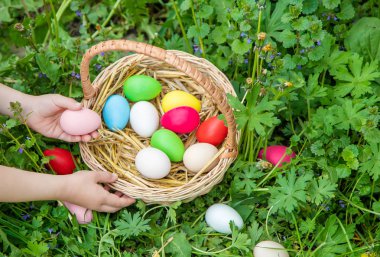 Krashenki sepette ev yapımı yumurta ve bir çocuğun elinde. Seçici odaklama.
