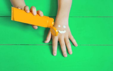 Bir çocuğun elinde güneş kremi. Seçici odaklama.