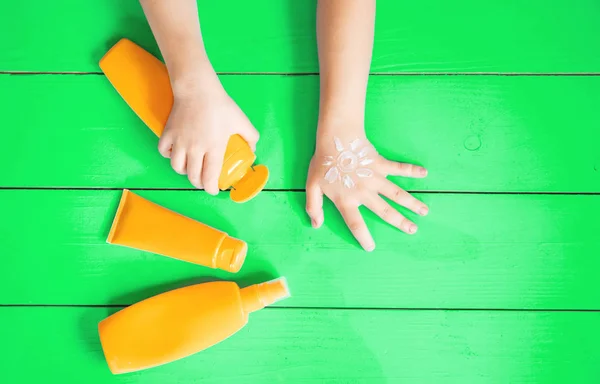 Sonnencreme auf der Hand eines Kindes. Selektiver Fokus. — Stockfoto