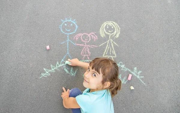 Дитина малює сім'ю на тротуарі з крейдою. Вибірковий фокус . — стокове фото