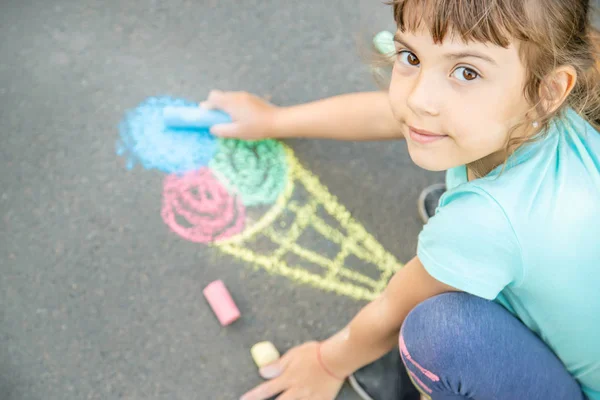 Kind zieht Eis mit Kreide auf Asphalt. Selektiver Fokus. — Stockfoto