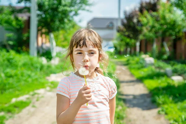 空気でタンポポを吹く少女。選択と集中. — ストック写真