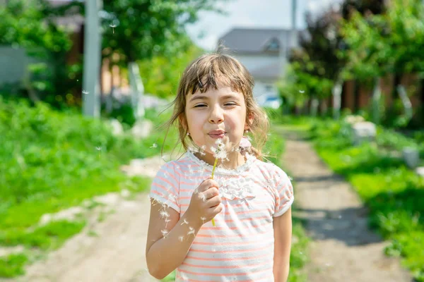 空気でタンポポを吹く少女。選択と集中. — ストック写真