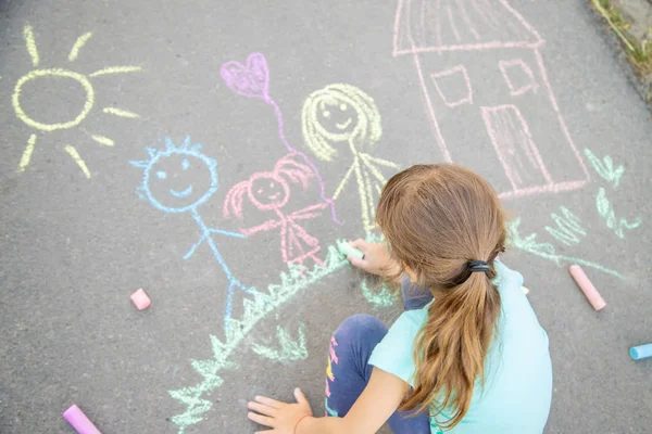 Child draws a family on the pavement with chalk. Selective focus. — Stock Photo, Image