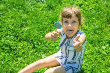 çocuk doğada lolipop yiyor. Seçici odaklama.