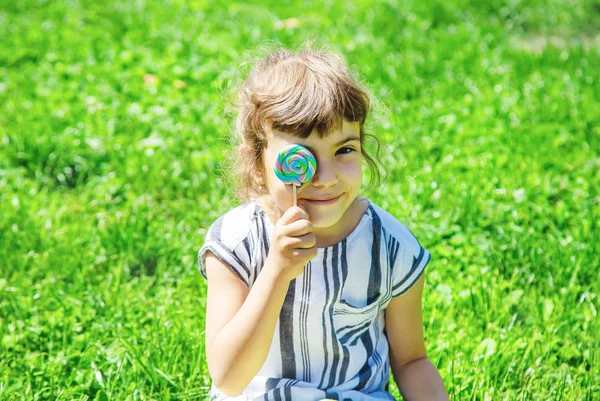 çocuk doğada lolipop yiyor. Seçici odaklama.