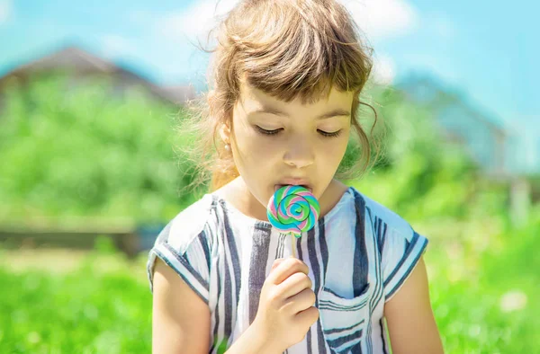 çocuk doğada lolipop yiyor. Seçici odaklama.