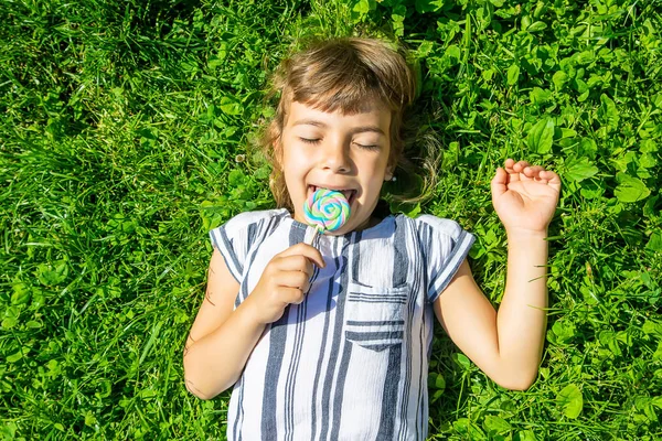 çocuk doğada lolipop yiyor. Seçici odaklama.