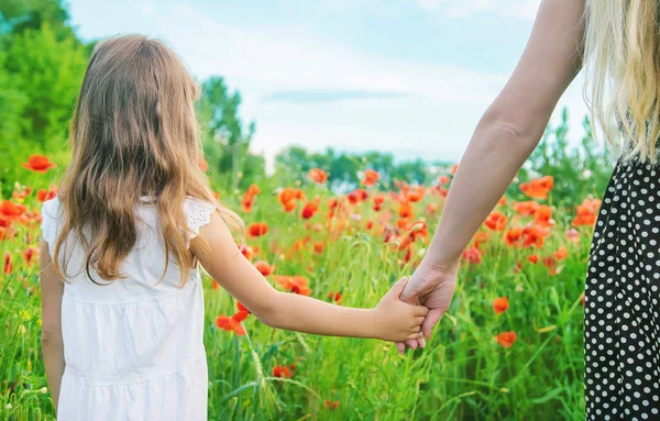 Kinderen meisje in een veld met klaprozen. selectieve focus. — Stockfoto