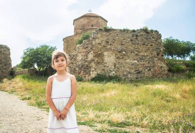 Georgia'nın turistik yerlerinin arka planında çocuk var. Jvari manastırının yanında. Seçici odaklama.