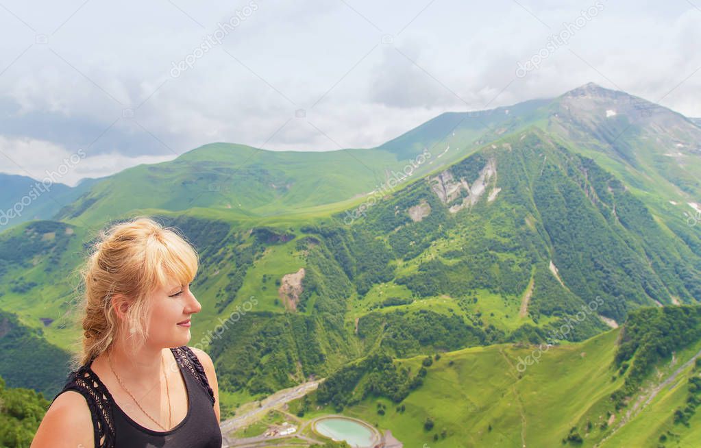 The girl looks at the mountains of Georgia. Selective focus.