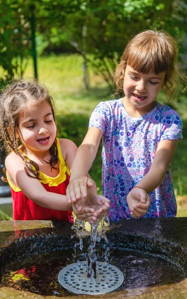 I bambini bevono acqua da una sorgente a Borjomi, Georgia. Focus selettivo . — Foto Stock