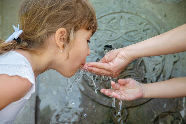 children drink water from a spring in Borjomi, Georgia. Selective focus.