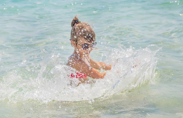 Niño hace spray en el mar. Enfoque selectivo . — Foto de Stock