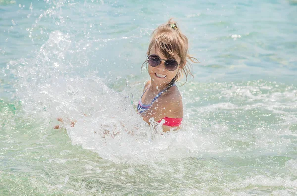 Child makes spray on the sea. Selective focus. — Stock Photo, Image