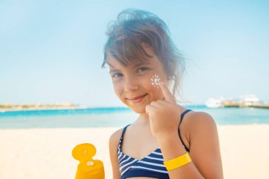 Bir çocuğun teninde güneş kremi. Seçici odak.