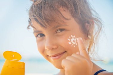 Bir çocuğun teninde güneş kremi. Seçici odak.