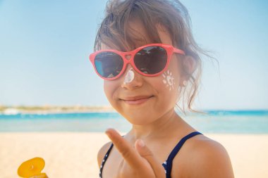 Bir çocuğun teninde güneş kremi. Seçici odak.