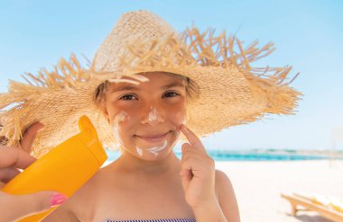 Bir çocuğun teninde güneş kremi. Seçici odak.