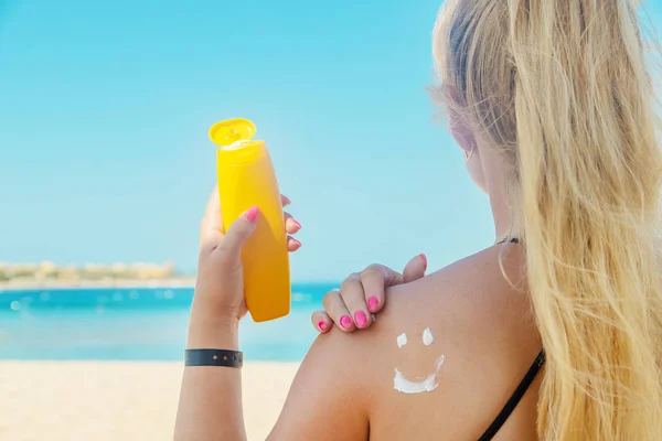 The girls on the beach wear sunscreen on their skin. Selective focus. — Stock Photo, Image