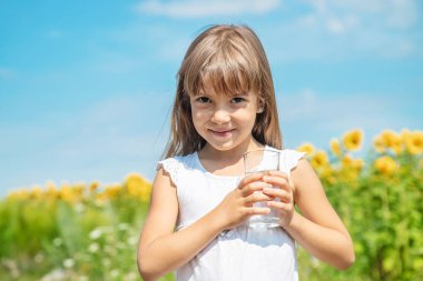 Bir çocuk tarlanın arka planında su içer. Seçici odaklama.