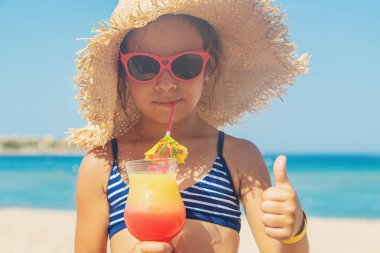 Denizde bir çocuk kokteyl içer. Seçici odak.