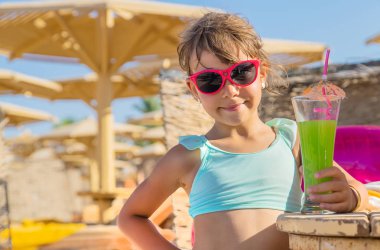 Denizde bir çocuk kokteyl içer. Seçici odak.