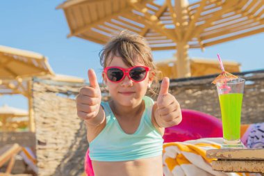 Denizde bir çocuk kokteyl içer. Seçici odak.