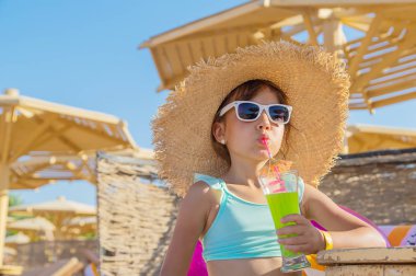 Denizde bir çocuk kokteyl içer. Seçici odak.