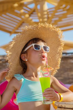 Denizde bir çocuk kokteyl içer. Seçici odak.