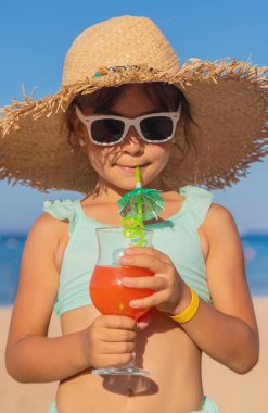 Denizde bir çocuk kokteyl içer. Seçici odak.