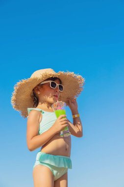 Denizde bir çocuk kokteyl içer. Seçici odak.