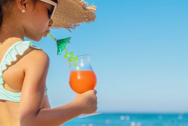 Denizde bir çocuk kokteyl içer. Seçici odak.