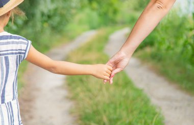 çocuk annesiyle el ele gider. Seçici odaklama.