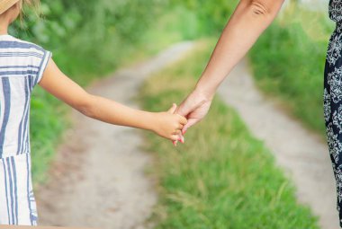 çocuk annesiyle el ele gider. Seçici odaklama.