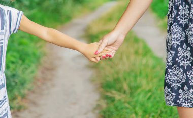 çocuk annesiyle el ele gider. Seçici odaklama.