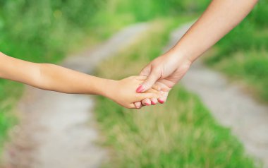 çocuk annesiyle el ele gider. Seçici odaklama.